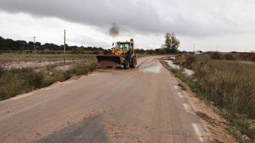 ecavadora retinrando lodo tras inundaciones carretera